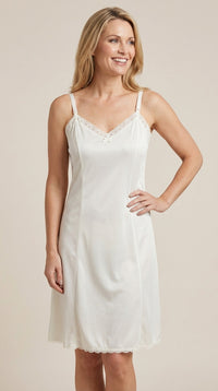 Woman wearing a ivory full slip against a beige background