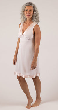 A woman in a flowing Pink Satin Touch Sleeveless Nightgown poses for the camera - side view