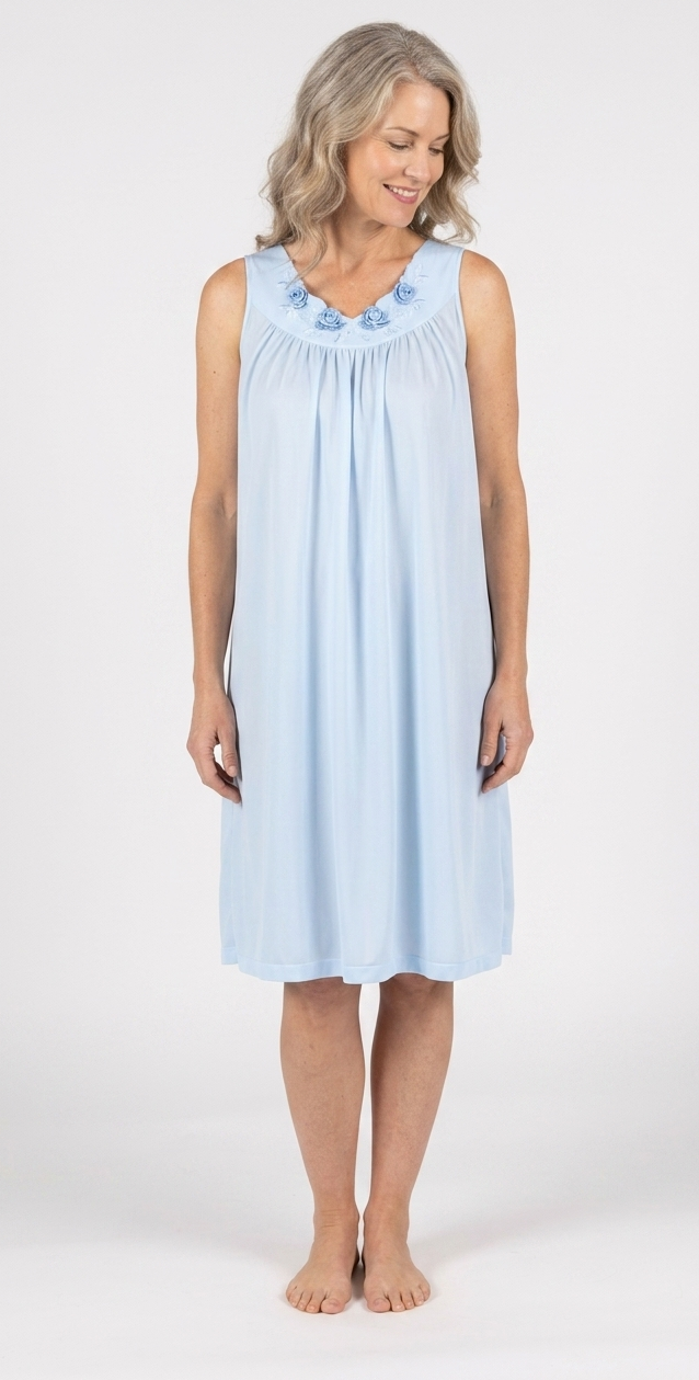 Woman wearing a light blue sleeveless dress with floral details on a white background